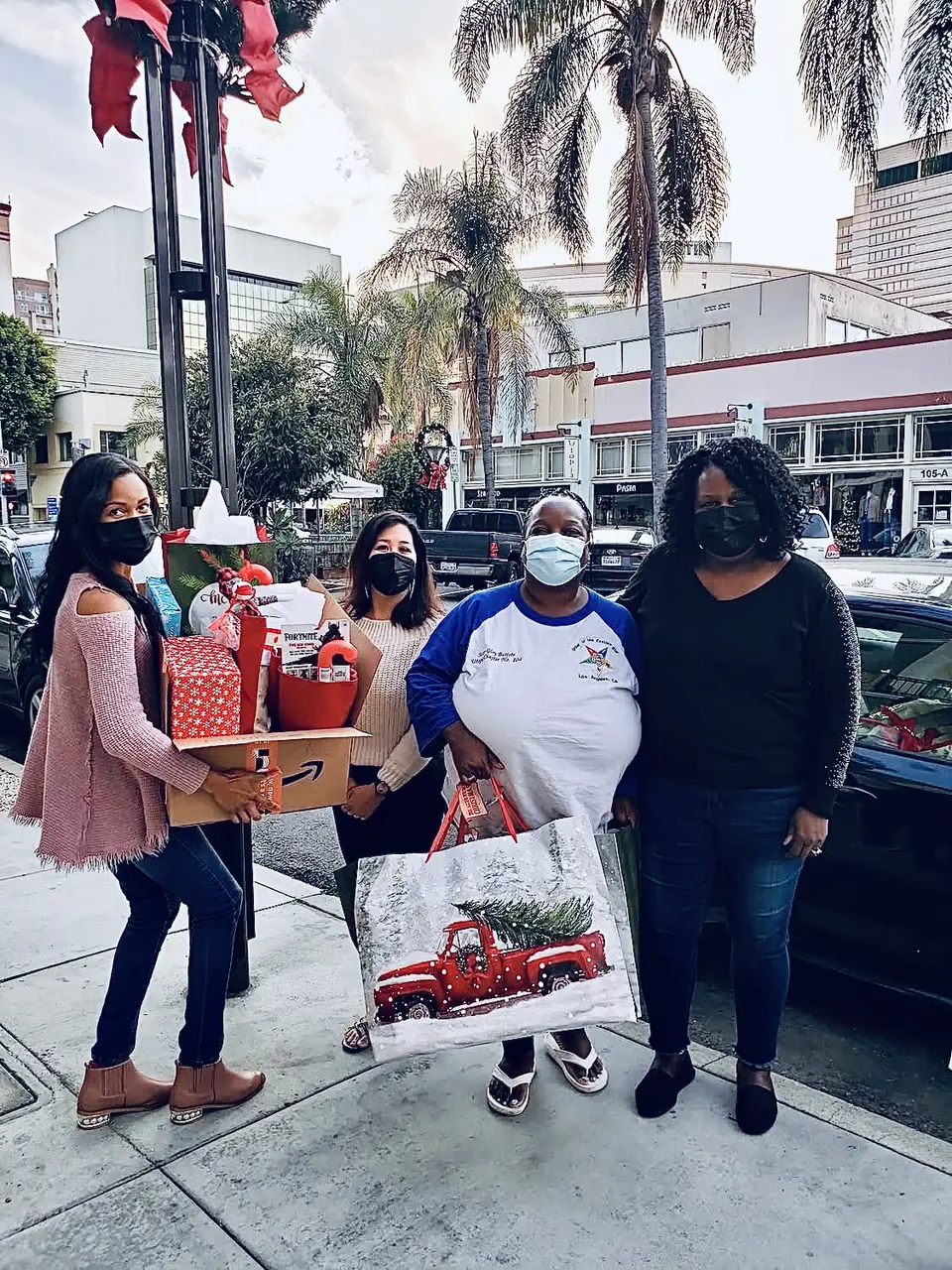 H.O.P.E. volunteers standing on a sidewalk with holiday gifts